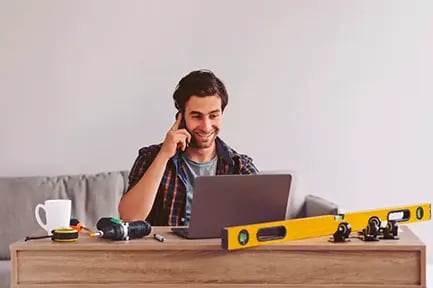 homem sorrindo olhando pro notebook